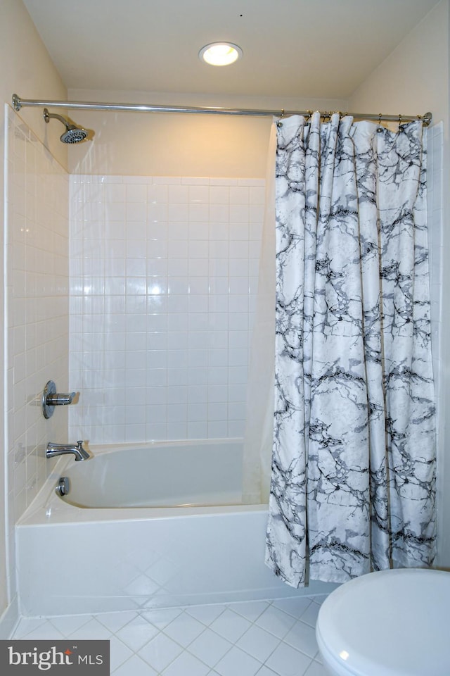 bathroom with tile patterned floors and shower / bath combo with shower curtain