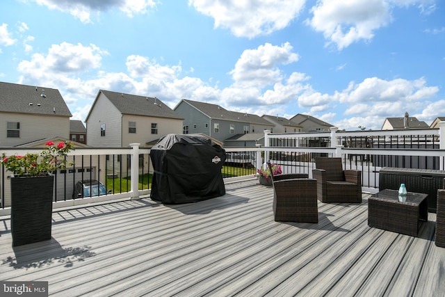 wooden terrace with area for grilling and an outdoor living space