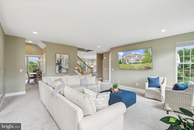 carpeted living room featuring an inviting chandelier