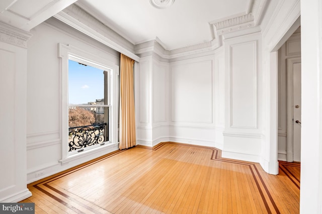 unfurnished room with a decorative wall and hardwood / wood-style floors