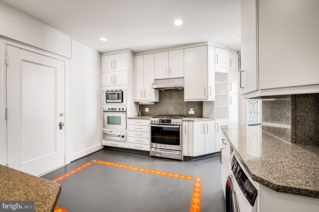 kitchen with washer / dryer, appliances with stainless steel finishes, white cabinetry, and decorative backsplash