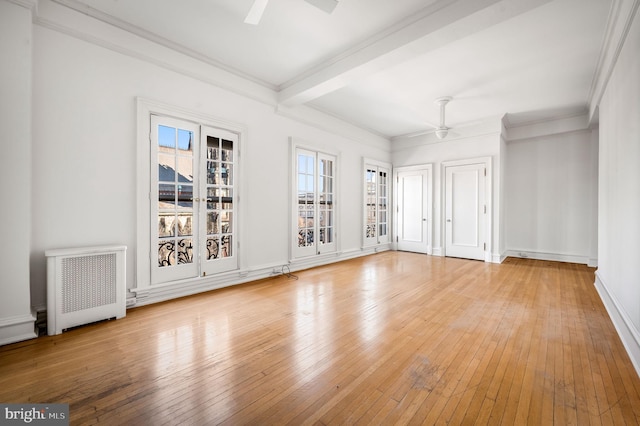 spare room featuring light wood-style floors, beamed ceiling, a ceiling fan, and radiator heating unit