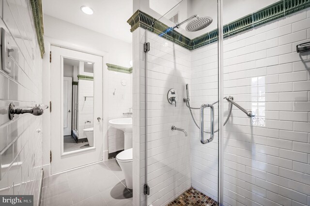 bathroom with tile patterned flooring, toilet, sink, and walk in shower