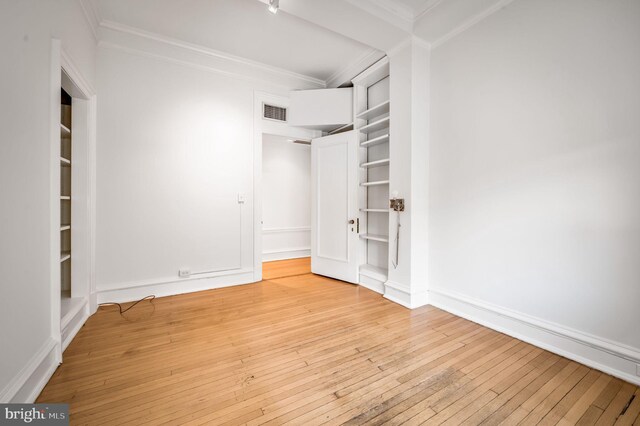 unfurnished bedroom with light wood-type flooring and crown molding