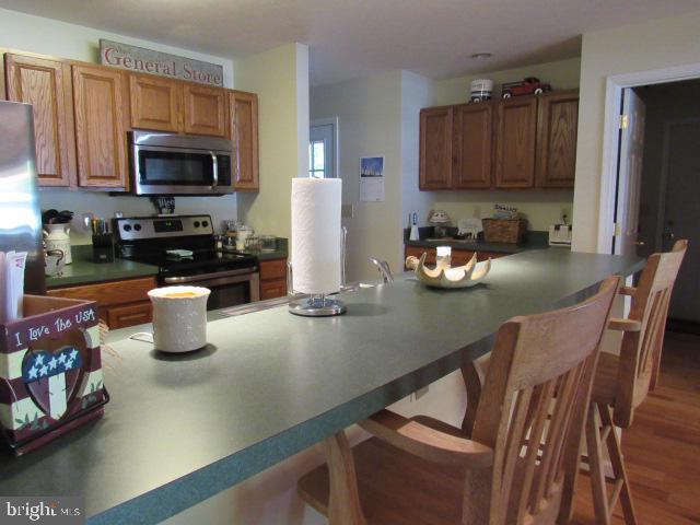 kitchen featuring appliances with stainless steel finishes and dark hardwood / wood-style floors