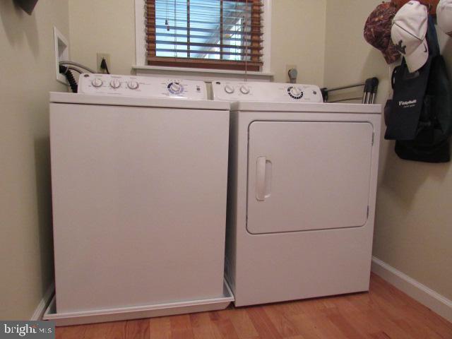 laundry area featuring washing machine and dryer and light wood-type flooring