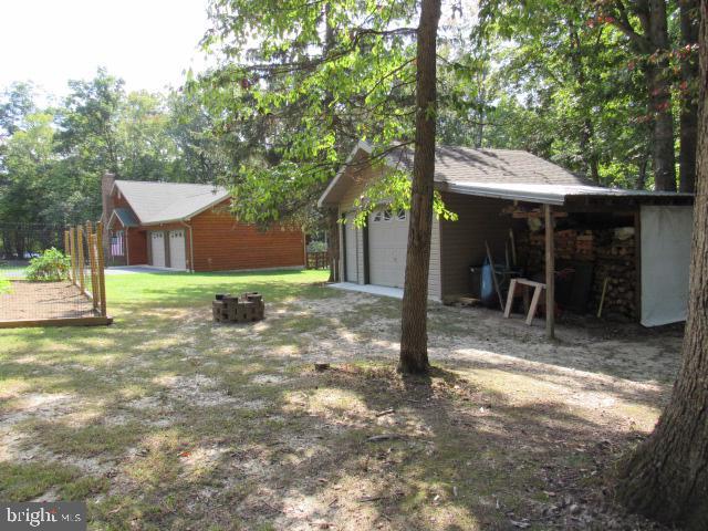 view of yard with a garage and an outdoor fire pit