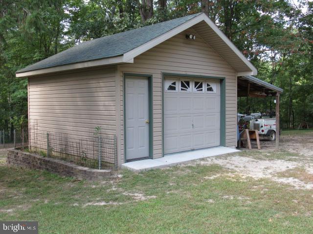 garage with a lawn and wooden walls