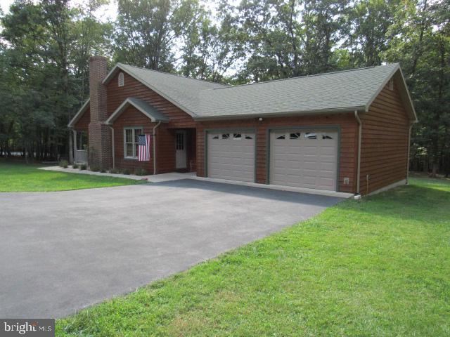 ranch-style home featuring a front lawn and a garage