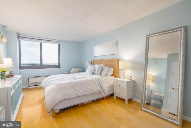 bedroom with radiator and light hardwood / wood-style floors