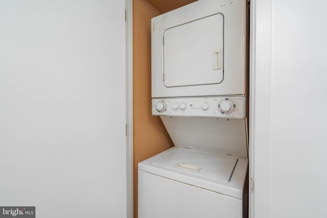 washroom with stacked washing maching and dryer