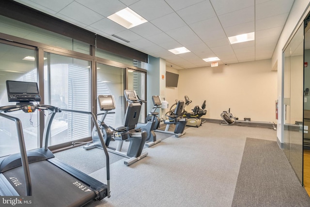 workout area featuring carpet and a paneled ceiling