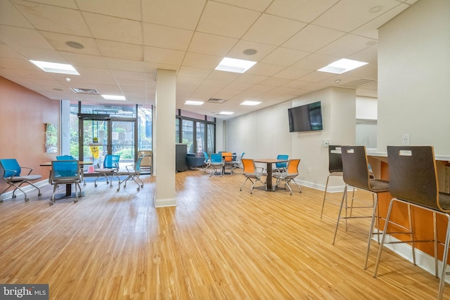 interior space with a paneled ceiling and light hardwood / wood-style flooring