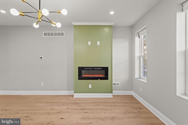 interior space with a fireplace, light hardwood / wood-style floors, and a notable chandelier