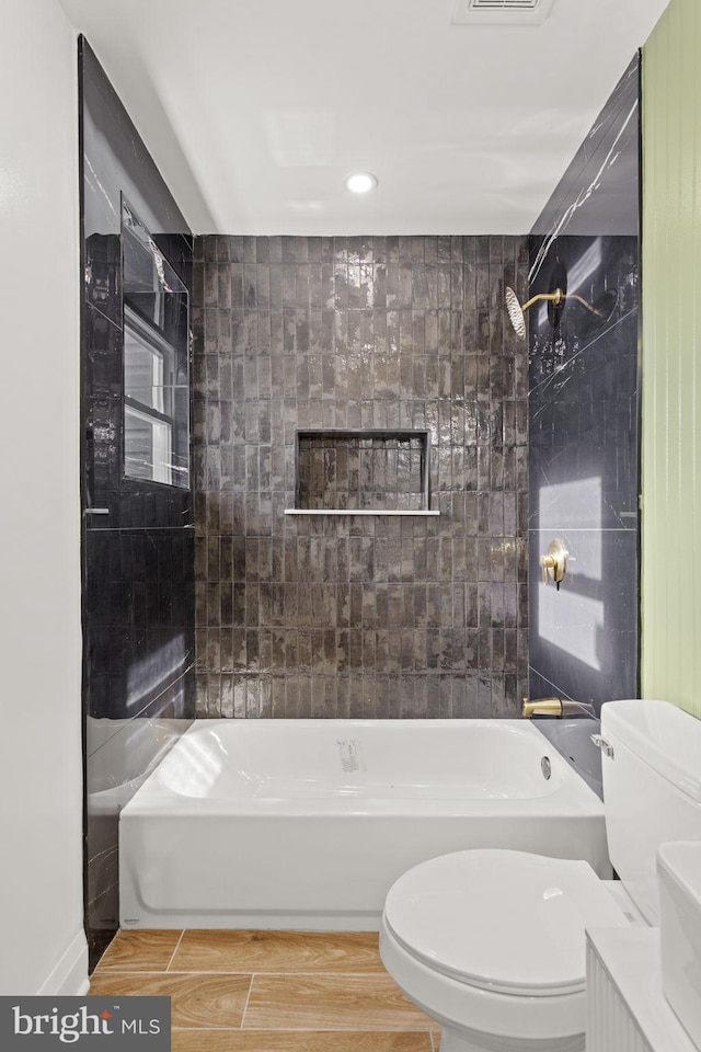 full bathroom featuring tiled shower / bath, toilet, and hardwood / wood-style flooring