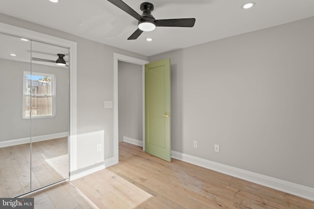 unfurnished bedroom featuring light wood-type flooring, ceiling fan, and a closet