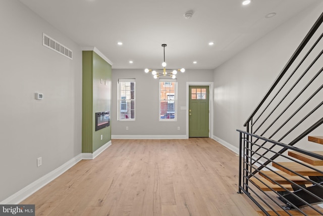 entrance foyer with a notable chandelier and light hardwood / wood-style floors