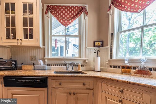 kitchen featuring light stone countertops and sink