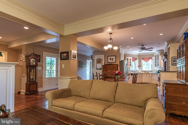 living room featuring ceiling fan with notable chandelier, ornamental molding, dark hardwood / wood-style floors, and a wealth of natural light