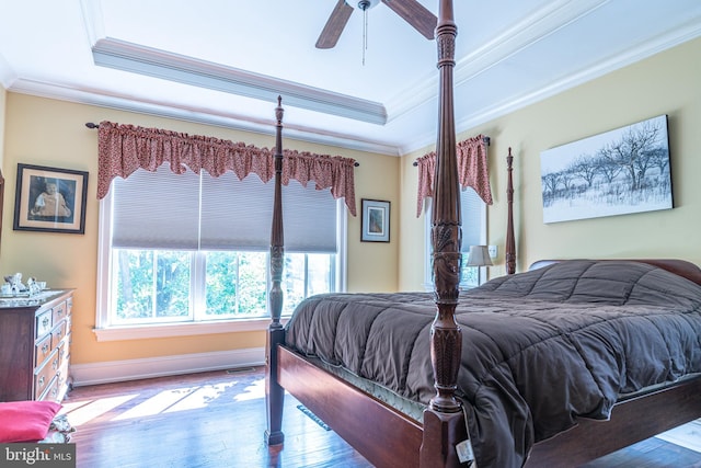 bedroom with a tray ceiling, ceiling fan, hardwood / wood-style floors, and crown molding