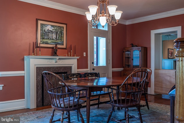 dining area with wood-type flooring, an inviting chandelier, and crown molding