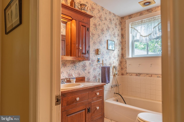 bathroom with vanity, a washtub, and toilet