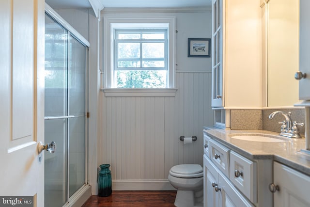 bathroom with vanity, hardwood / wood-style floors, toilet, and an enclosed shower