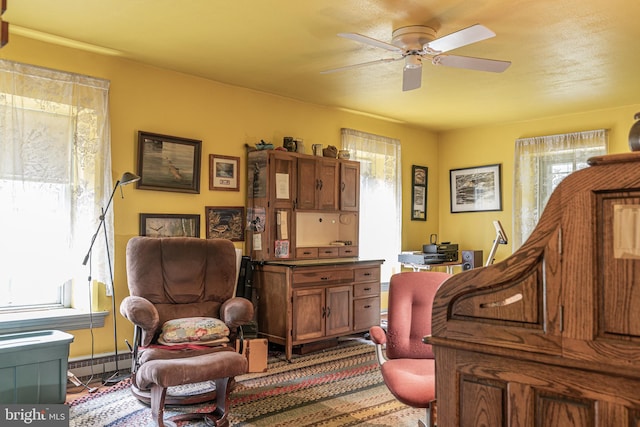 sitting room with a baseboard radiator and ceiling fan