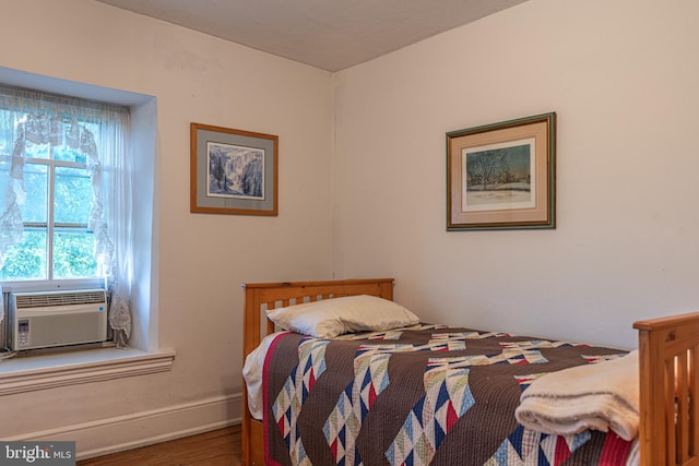 bedroom featuring wood-type flooring and cooling unit