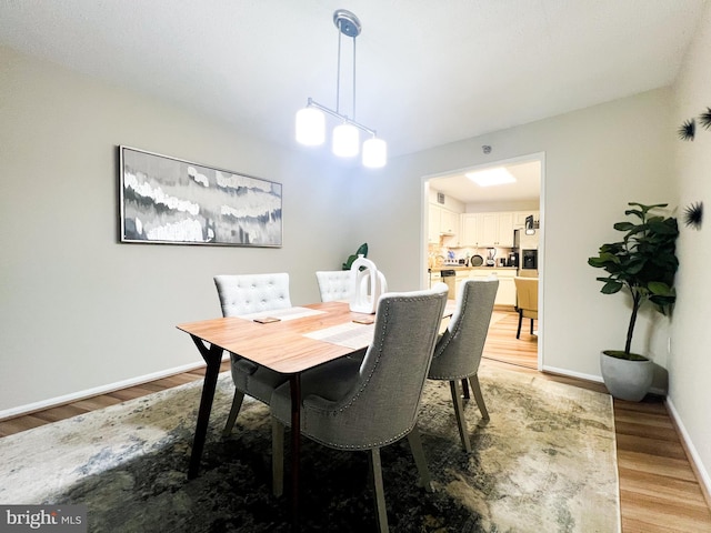 dining room featuring baseboards and light wood-style floors