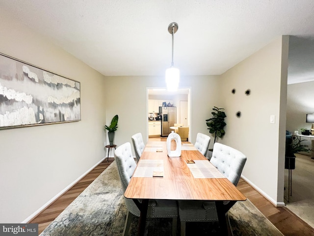 dining area with baseboards and wood finished floors