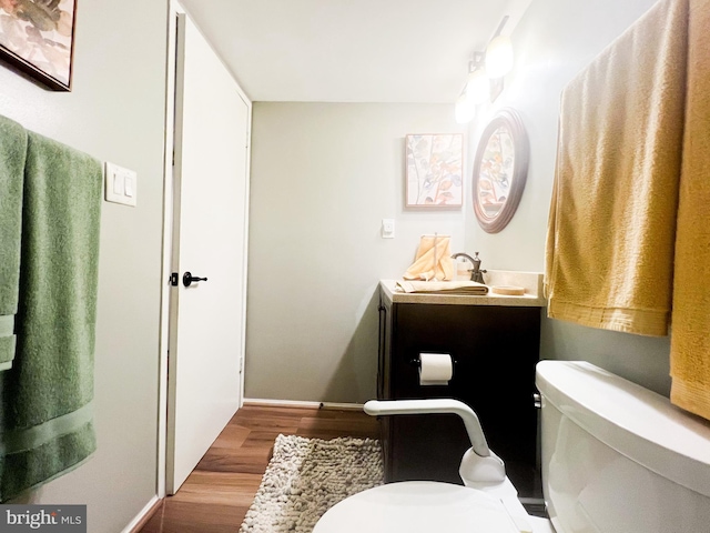 bathroom featuring toilet, wood finished floors, and vanity