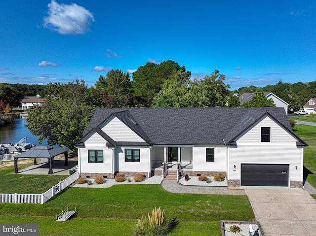 view of front facade with a garage, a water view, and a front lawn