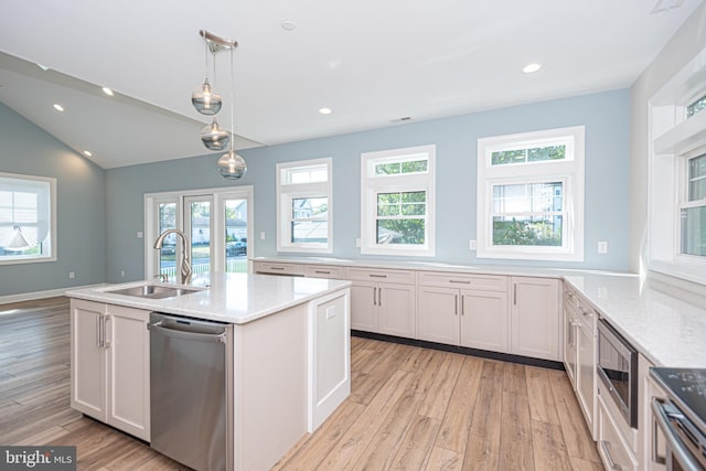 kitchen featuring white cabinets, sink, decorative light fixtures, light hardwood / wood-style flooring, and stainless steel appliances