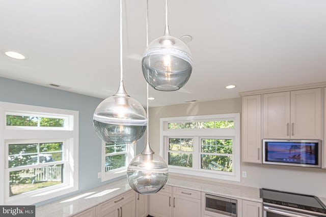 kitchen with stainless steel appliances, light stone counters, and white cabinets