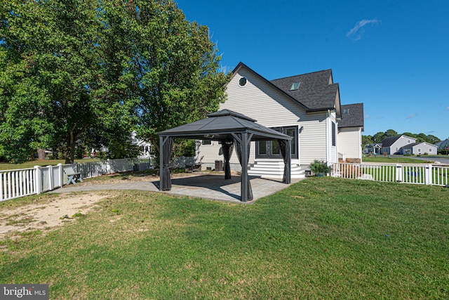 rear view of property featuring a gazebo, a yard, and a patio area