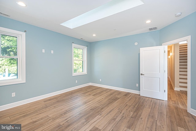 interior space with a skylight and light wood-type flooring