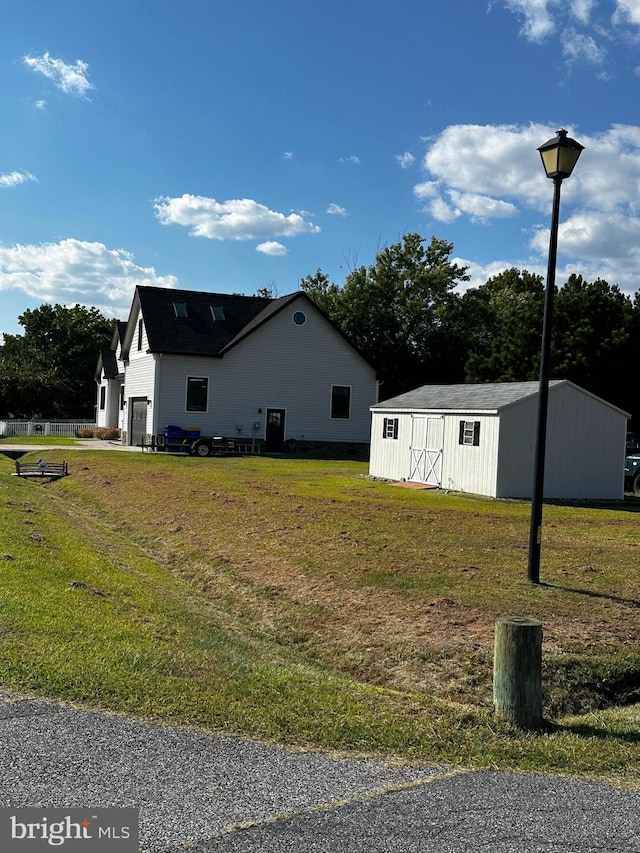 view of home's exterior with a storage unit and a lawn