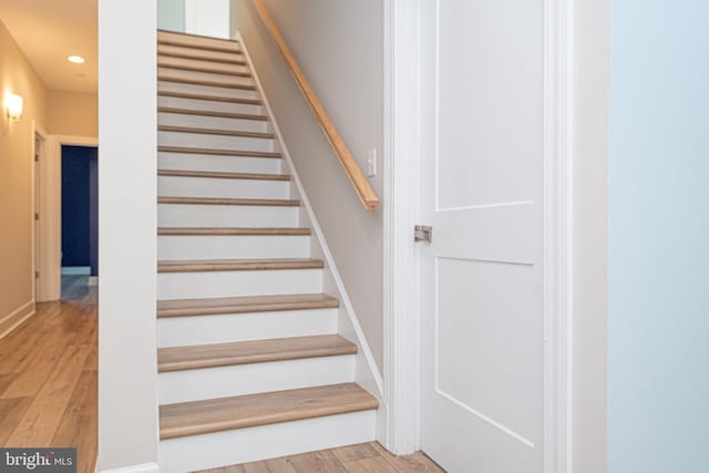 staircase with hardwood / wood-style flooring