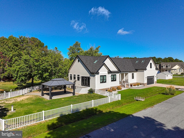 view of front of home with a garage, a gazebo, and a front lawn