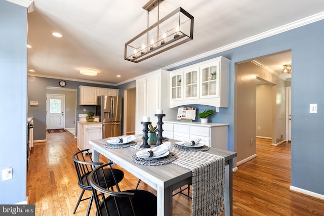 dining room featuring light hardwood / wood-style flooring and crown molding