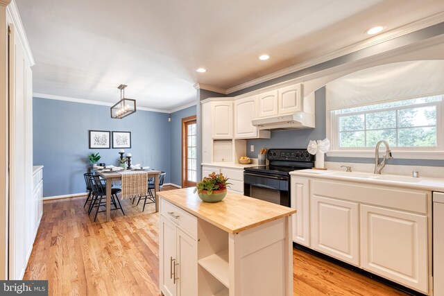 kitchen featuring light wood-type flooring, sink, white cabinetry, hanging light fixtures, and black / electric stove