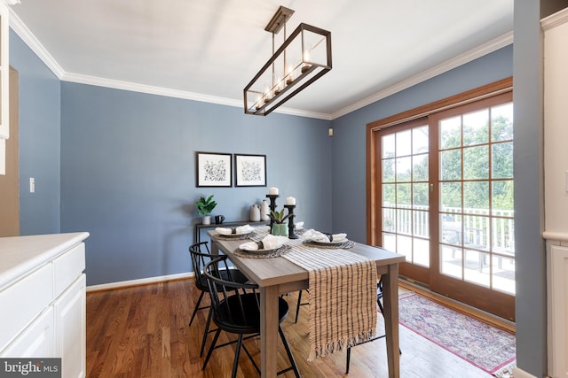 dining space featuring ornamental molding and dark hardwood / wood-style flooring