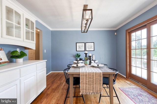 dining space with wood-type flooring and crown molding