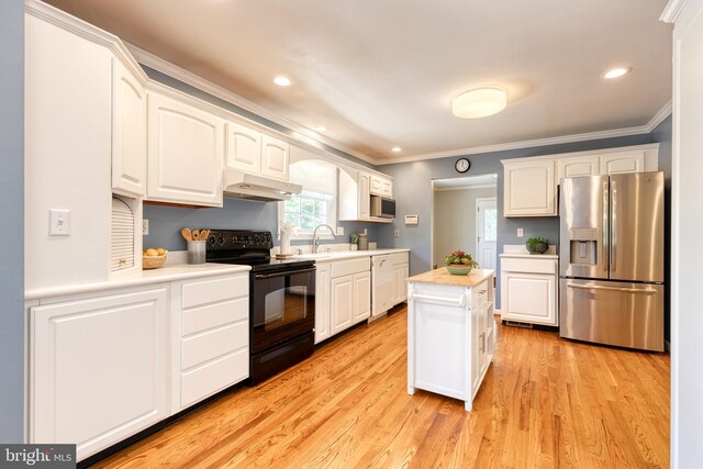 kitchen featuring light hardwood / wood-style flooring, white cabinetry, appliances with stainless steel finishes, and a kitchen island