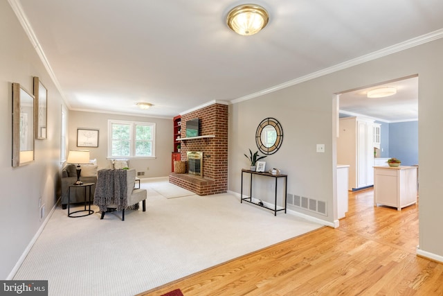 interior space with light hardwood / wood-style flooring, a brick fireplace, and ornamental molding