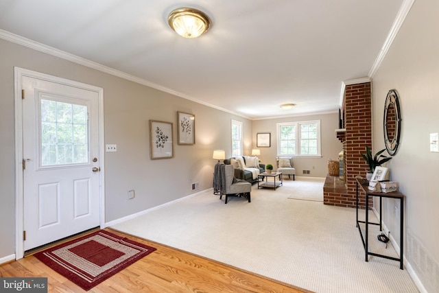 entryway with ornamental molding and hardwood / wood-style flooring