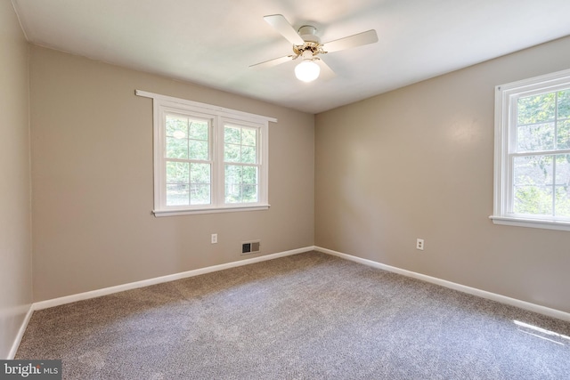 spare room featuring ceiling fan, plenty of natural light, and carpet flooring