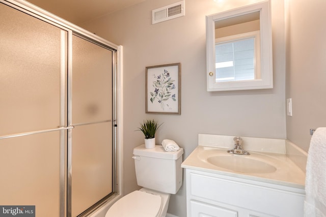 bathroom featuring an enclosed shower, vanity, and toilet