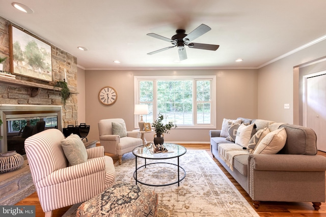 living room with ceiling fan, a fireplace, crown molding, and hardwood / wood-style floors